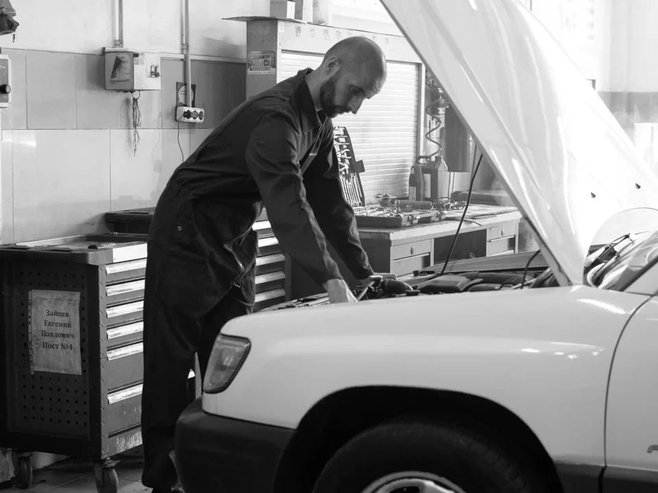 Profissional inspecionando o motor de um carro em oficina