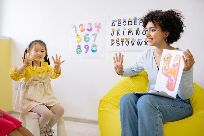 Educadora e criança explorando números com as mãos
