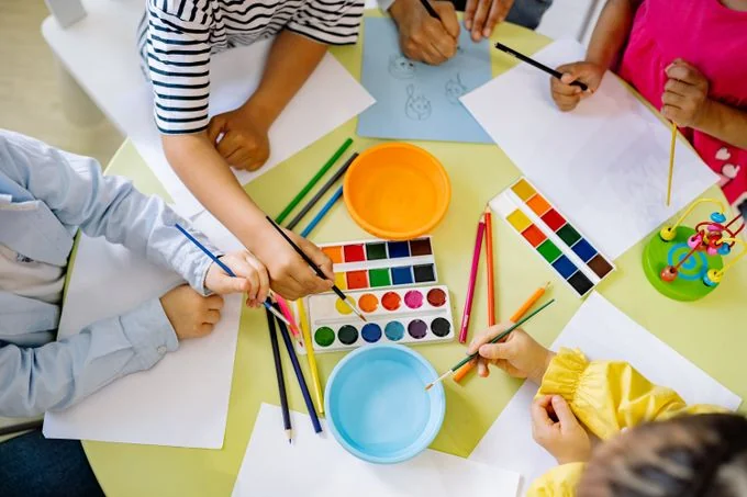 Crianças explorando pintura em uma atividade coletiva