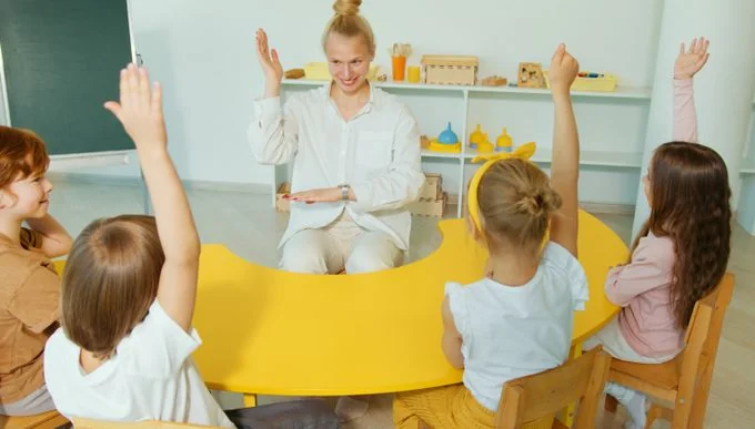 Crianças levantando as mãos em uma conversa com a educadora