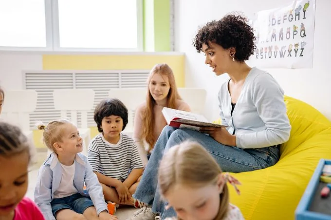 Educadora lendo com crianças em uma roda