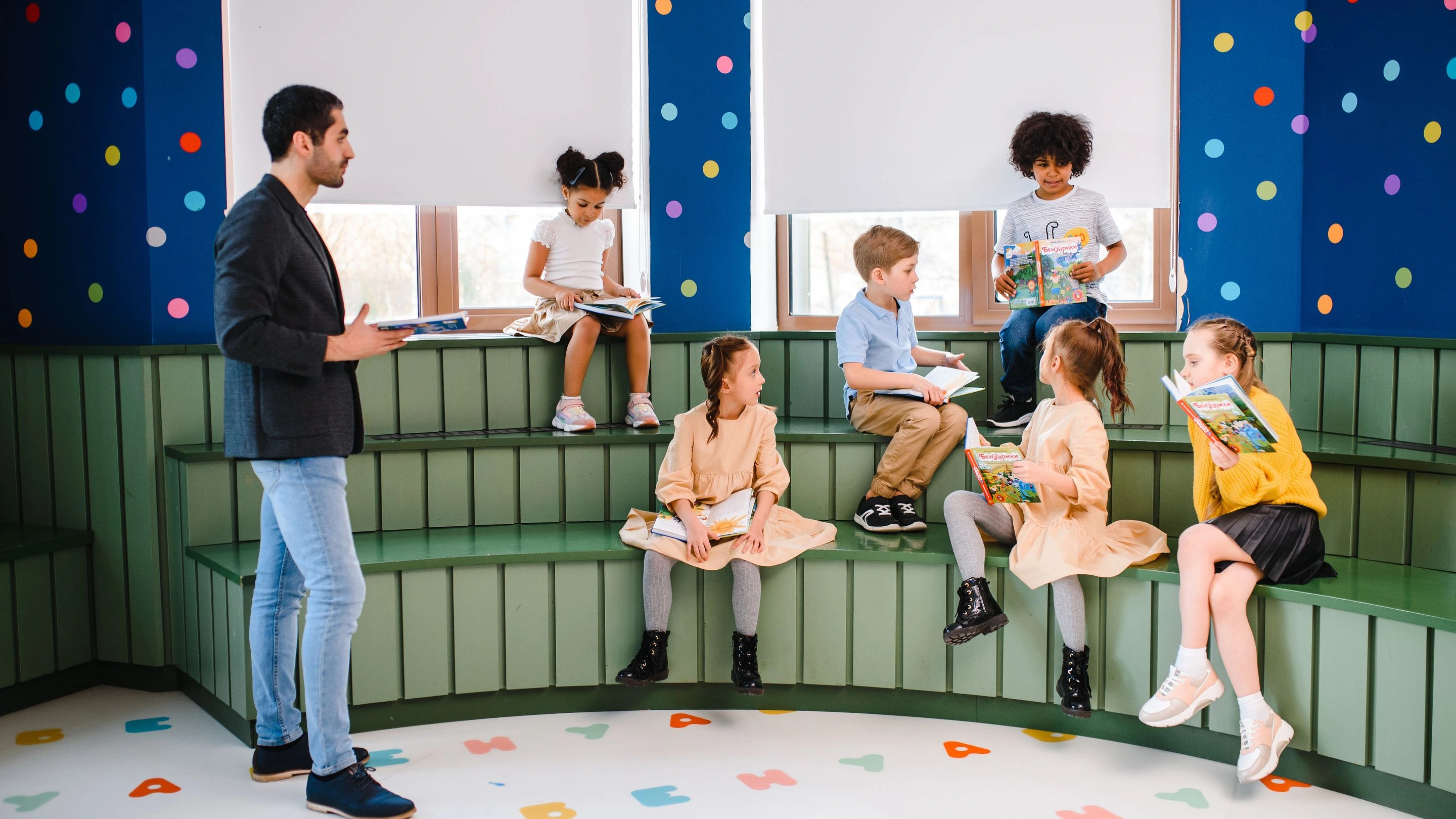 Educador e crianças compartilhando livros em um espaço de leitura