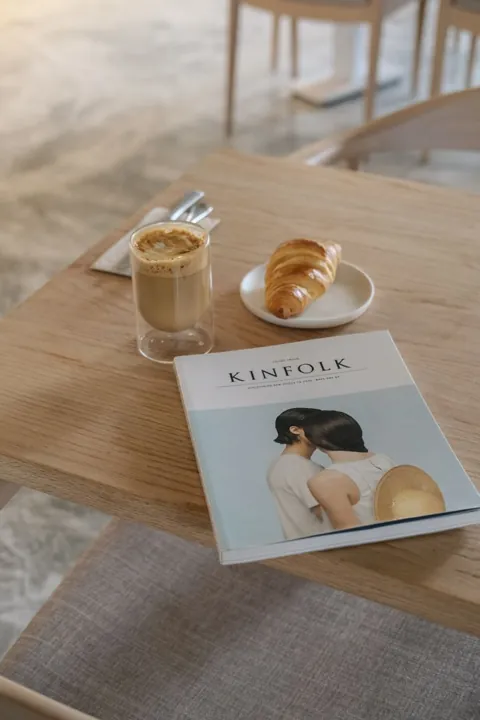 Croissant, café e uma revista sobre a mesa