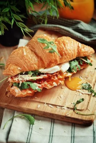 Croissant recheado com ovo e folhas verdes