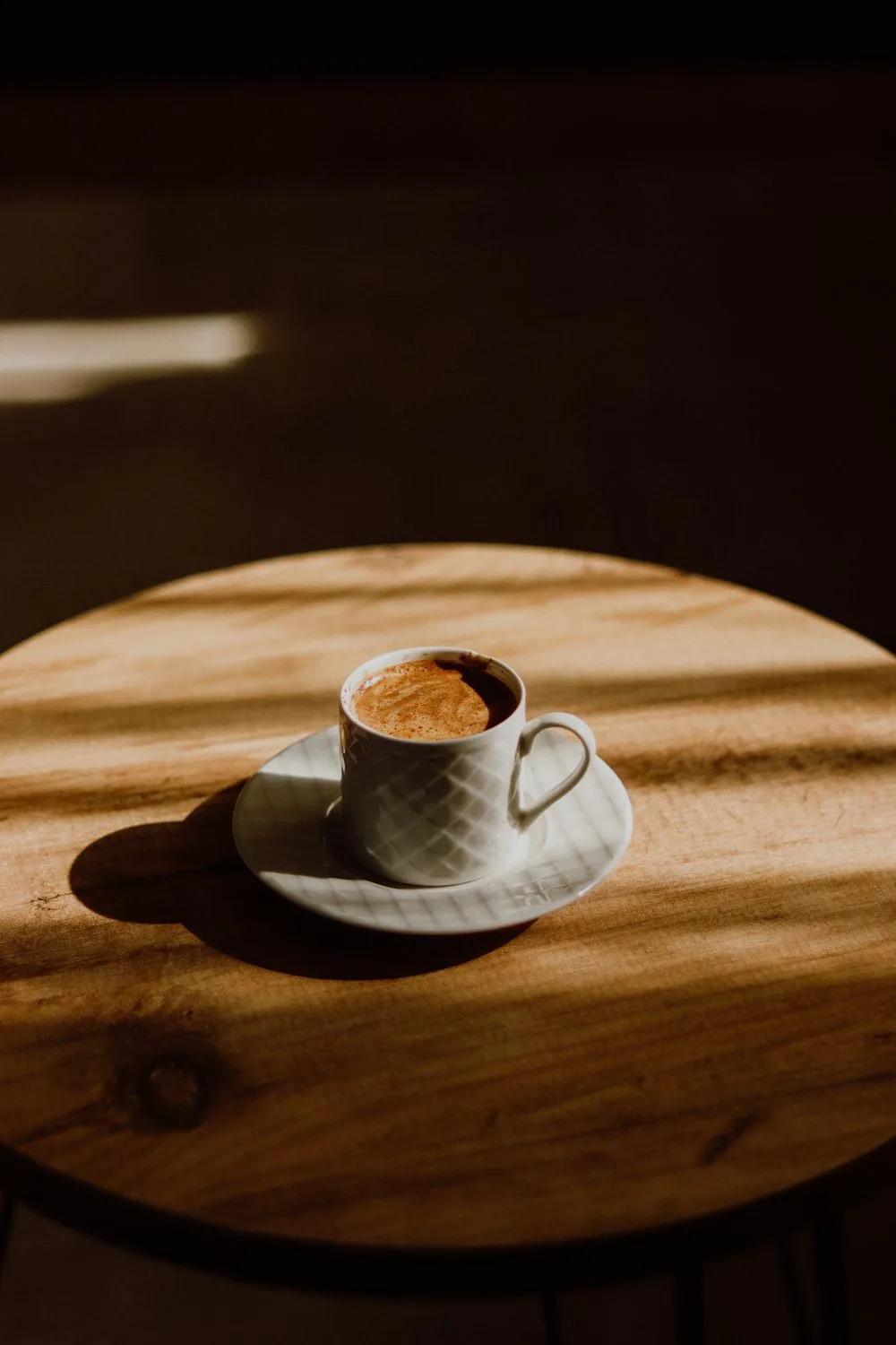 Xícara de espresso em uma mesa iluminada pelo sol