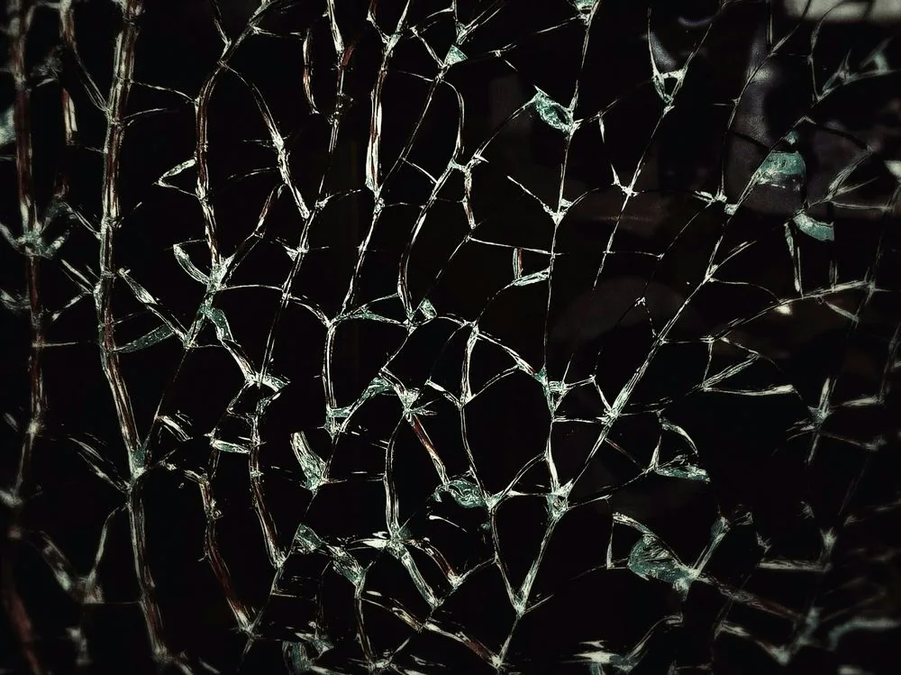 Tela de smartphone rachada sobre a bancada