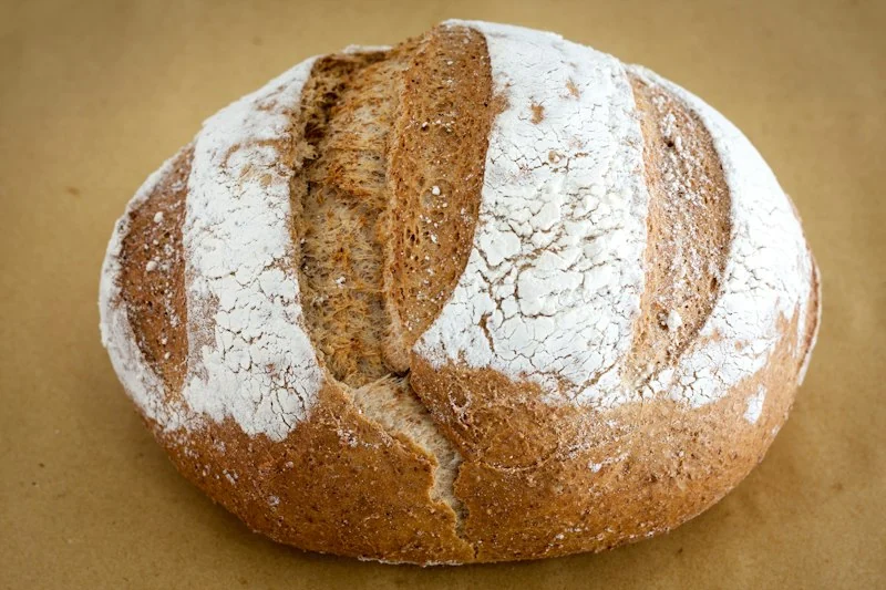 Pão redondo de fermentação natural com corte rústico na superfície